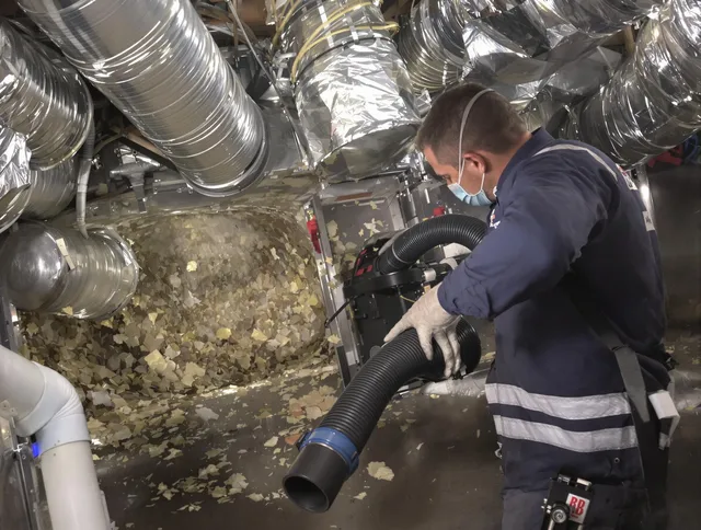 Raynham Air Duct Cleaning specialist operating negative pressure cleaning equipment for thorough duct maintenance in Raynham